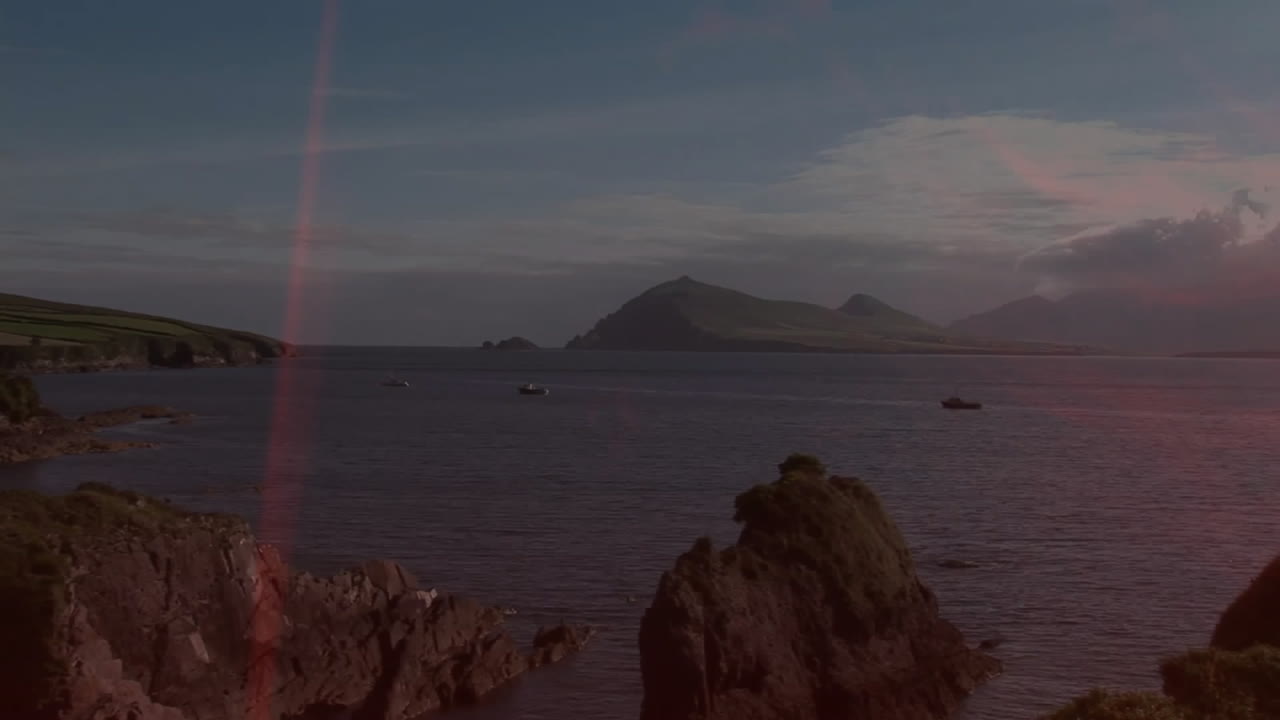 Boats on calm water near rocky coastline under clear blue sky