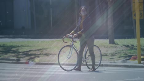 animación de formas que se mueven sobre una mujer biracial con máscara facial caminando con bicicleta