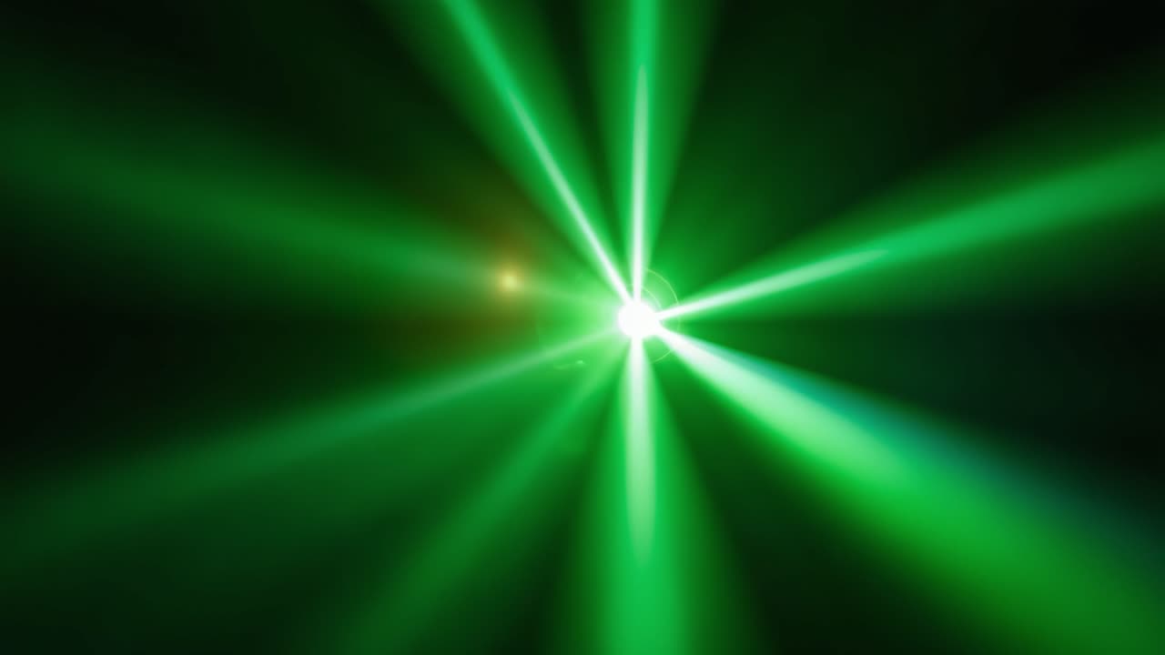 Immagine dinamica di un raggio laser verde che emette luce intensa in un ambiente buio, creando motivi luminosi suggestivi ed effetti radiosi in una visualizzazione accattivante