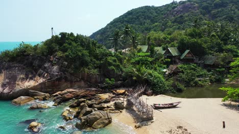 Fishing-boat-and-a-wooden-deck-on-the-Haad-Than-Sadet-Beach,-Koh-Phangan,-Thailand-during-the-low-tide