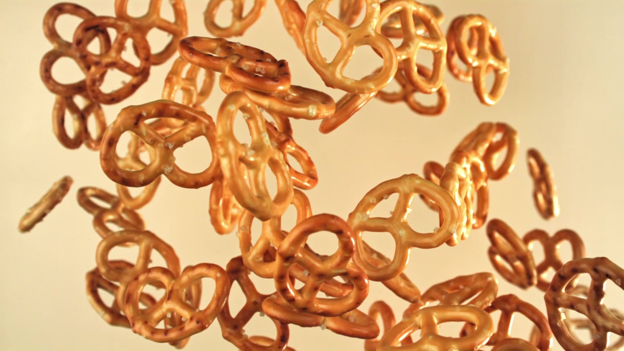 Gylne minipretzeler faller i sakte film