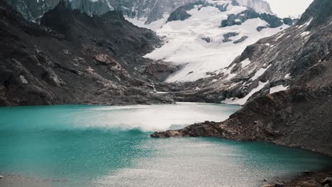 tilt-up reveal of glacier and mount fitz roy across laguna de los tres in el chalten, argentina