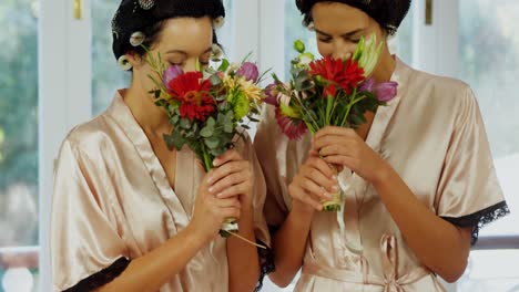 Excited-bridesmaids-in-nightdress-and-hair-rollers-smelling-the-flowers-4K-4k