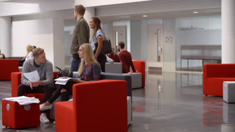 students walking through meeting area in a university lobby