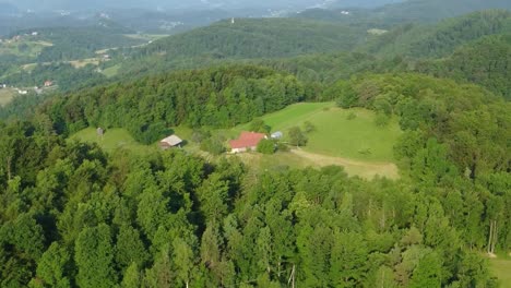 big family house with wooden barn in the middle of green forest and surrounded with meadows