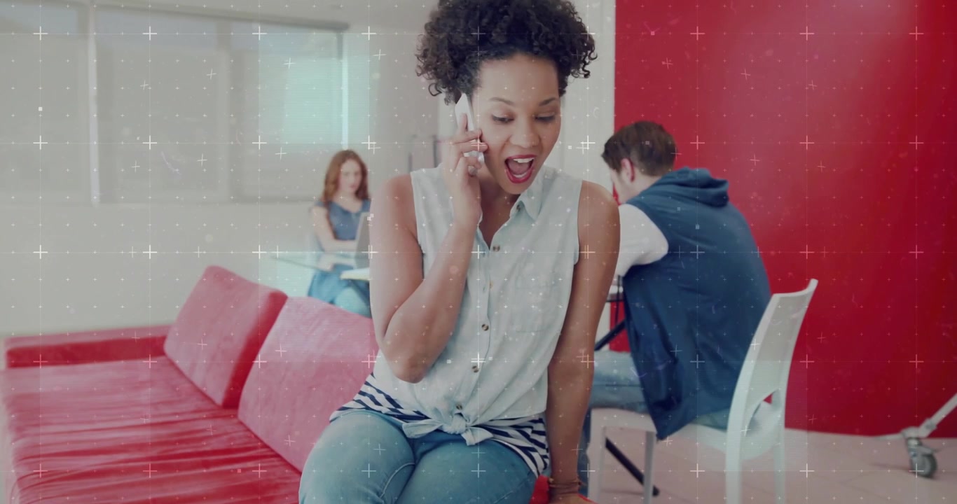 Seated woman answering smartphone call, smiling, shifting while sparkles floating over business hub