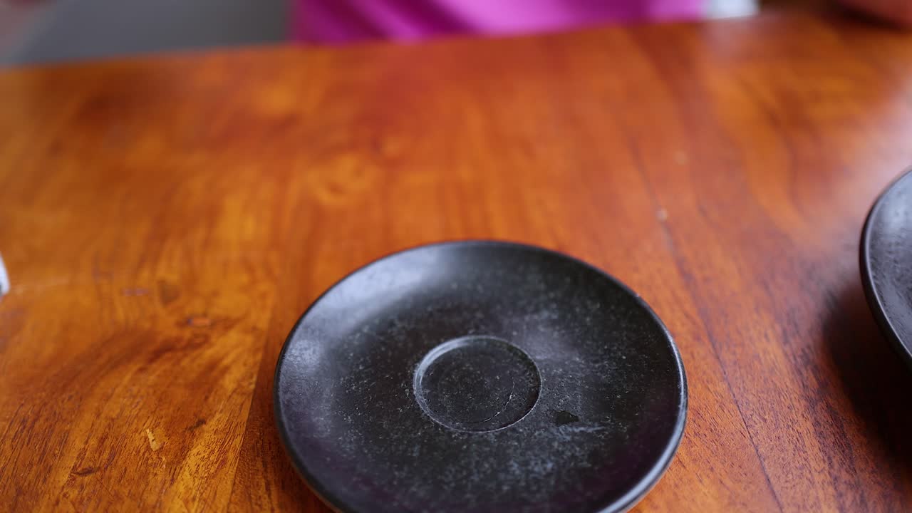 levanta la mano y coloca la taza de té en el platillo