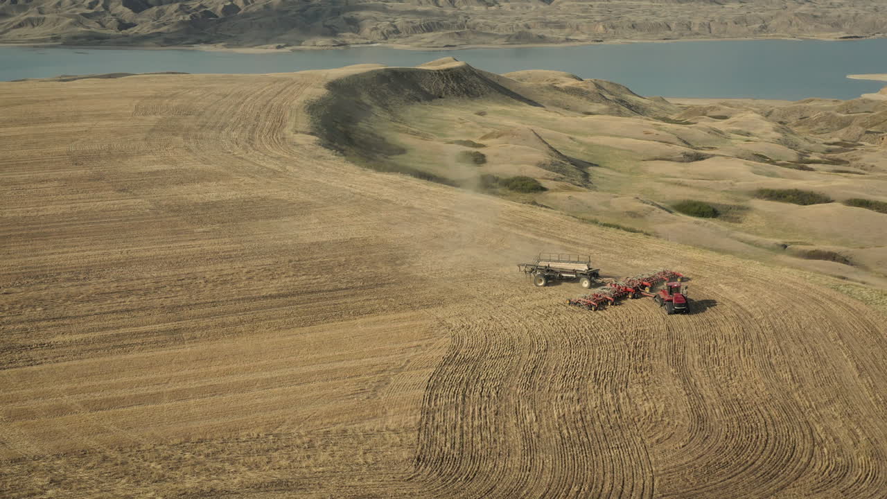 캐나다 서스캐처원에 트랙터가 그려진 경운기 파종기가 있는 파종장