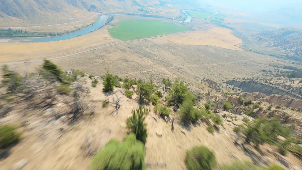 drone fpv volando por el valle de la pendiente de la colina de la montaña seca con el río