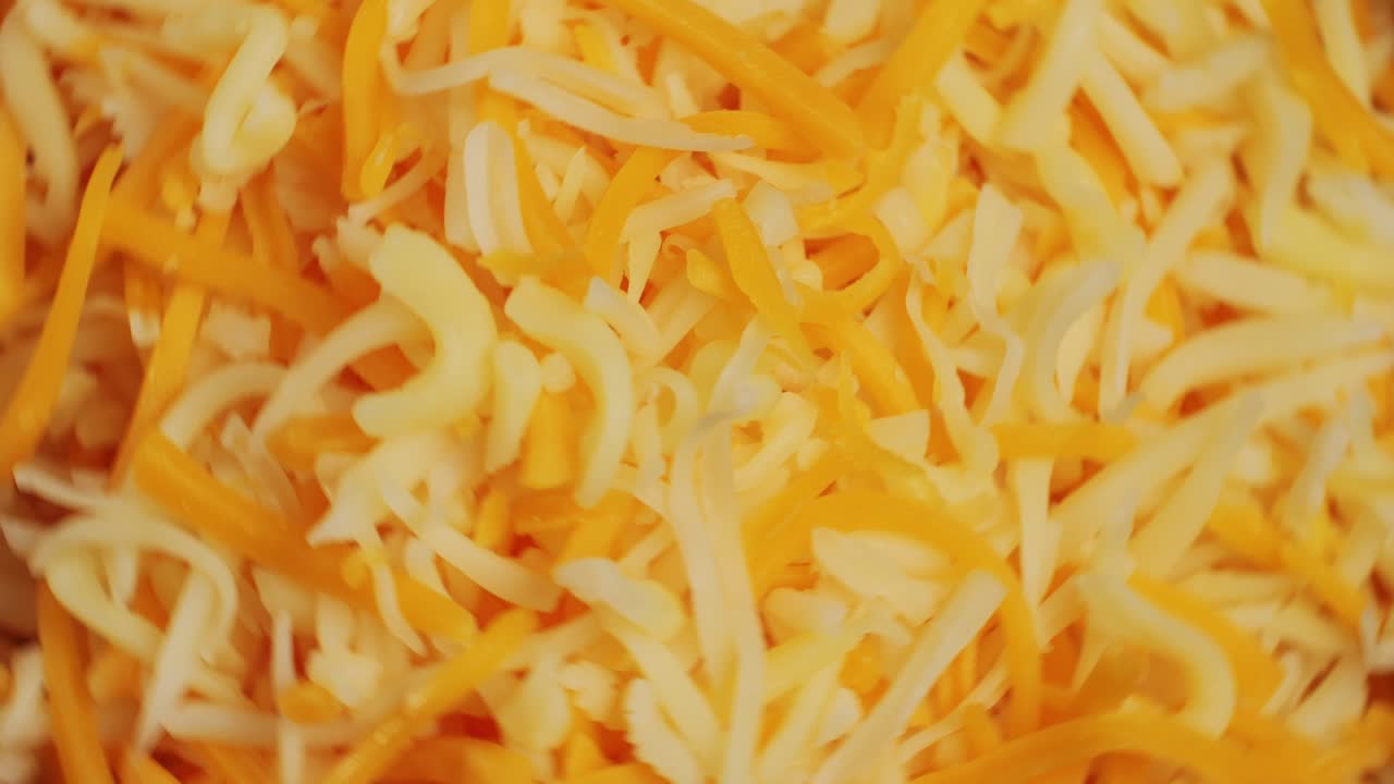 Some different sorts of grate cheese on plate close up macro. Chef grating cheese mozzarella, cheddar for meals. Itallian food, pizza, pasta. High quality 4k footage
