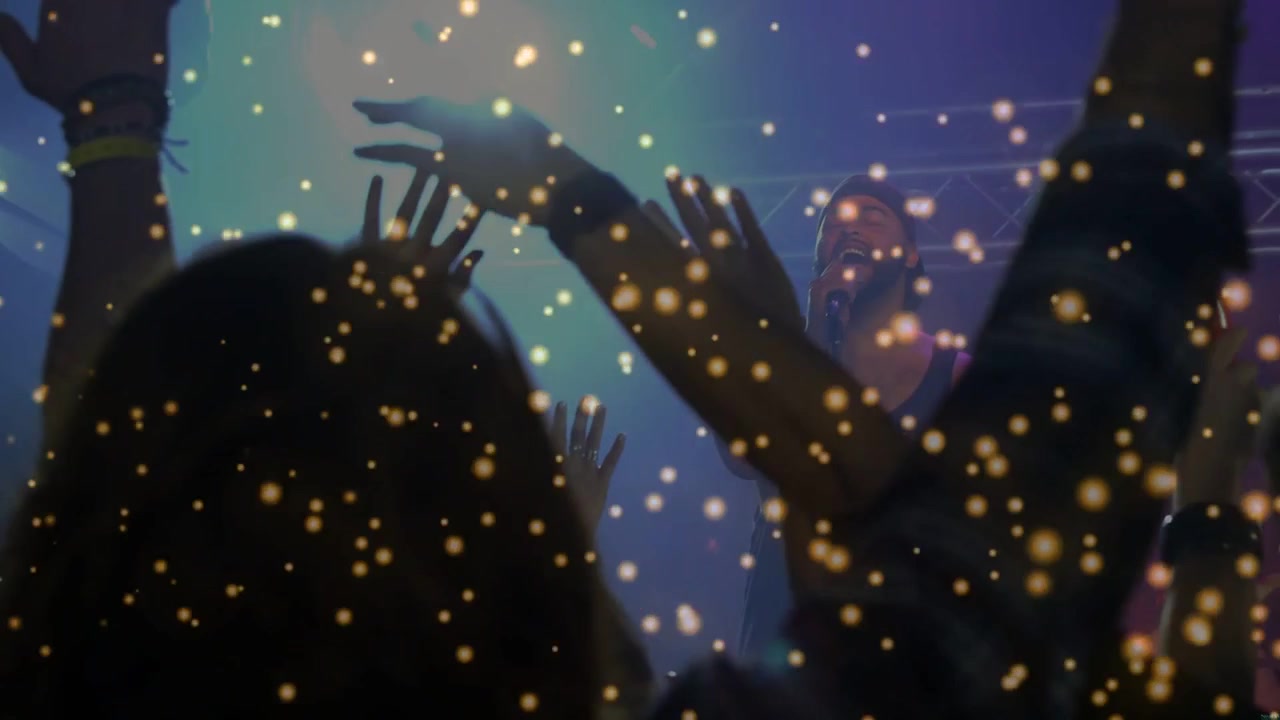 Vertikal video: Fan på første række til koncert løftes op og når scenen, mens performer synger, med konfetti