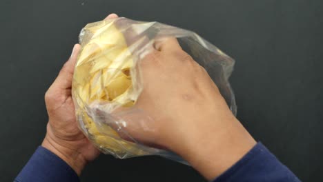 hand holding a bag of potato chips