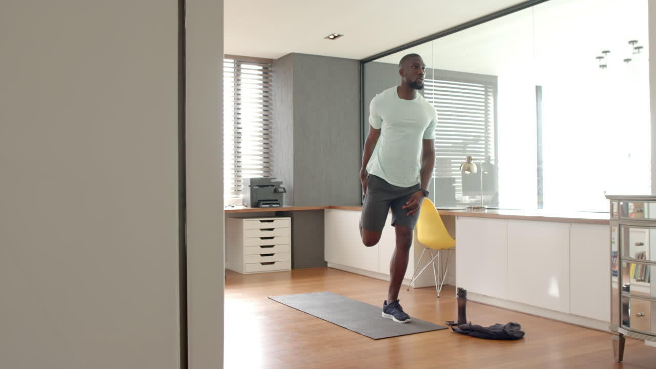 Uomo in forma che fa stretching sul tappetino da yoga, si allena in un moderno ambiente di ufficio domestico.