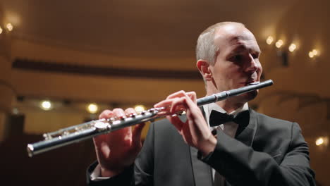 Proben-Des-Symphonieorchesters-Oder-Bläserensembles-In-Der-Alten-Music-Hall,-Grauhaariger-Flötist-Spielt-Auf-Der-Bühne