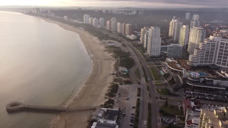 Vista-Aérea-De-La-Ciudad-Costera,-Punta-Del-Este-Que-Muestra-La-Carretera-Costera-A-Lo-Largo-De-La-Costa