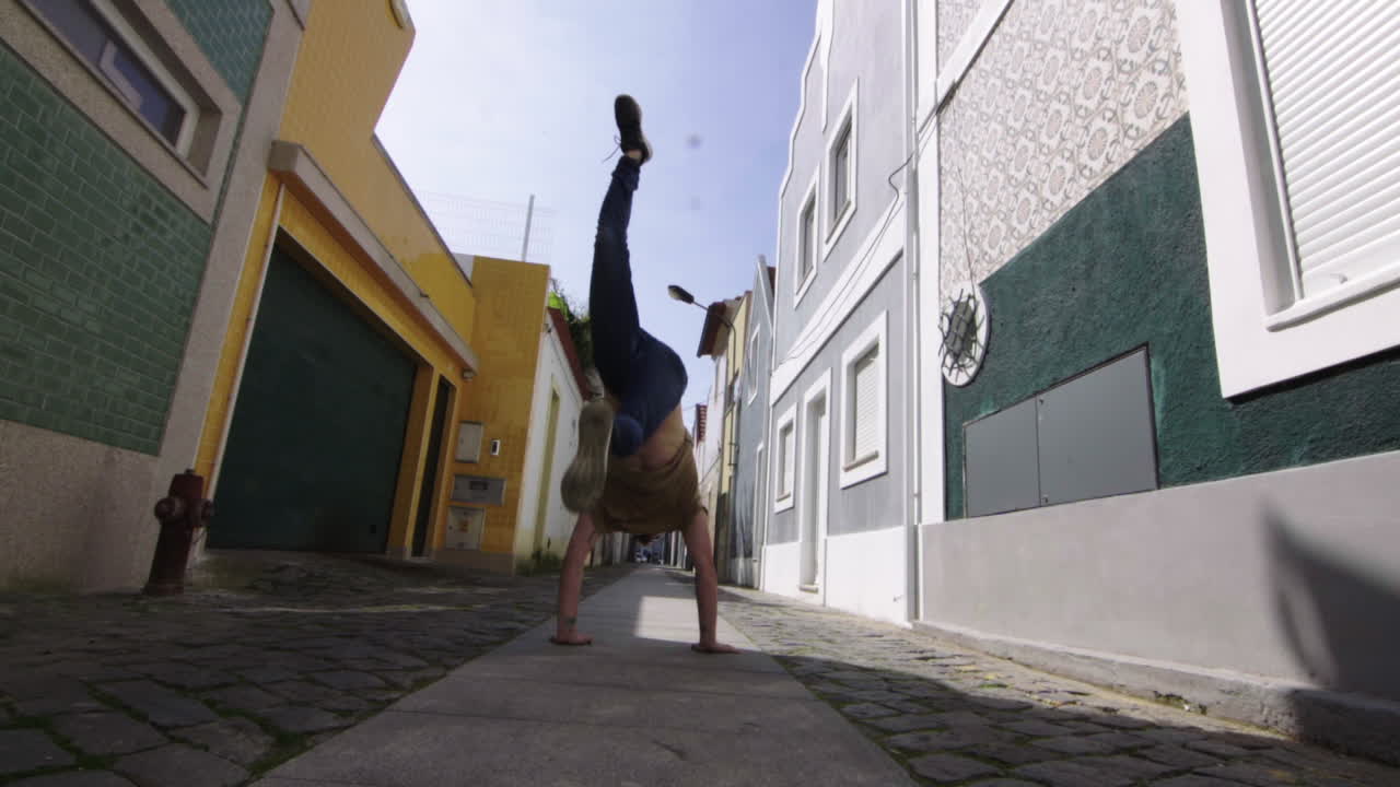 Jovem turista caucasiano atlético e alegre de pé numa rua estreita no centro do Porto, Portugal, celebrando um estilo de vida feliz durante as suas férias de verão
