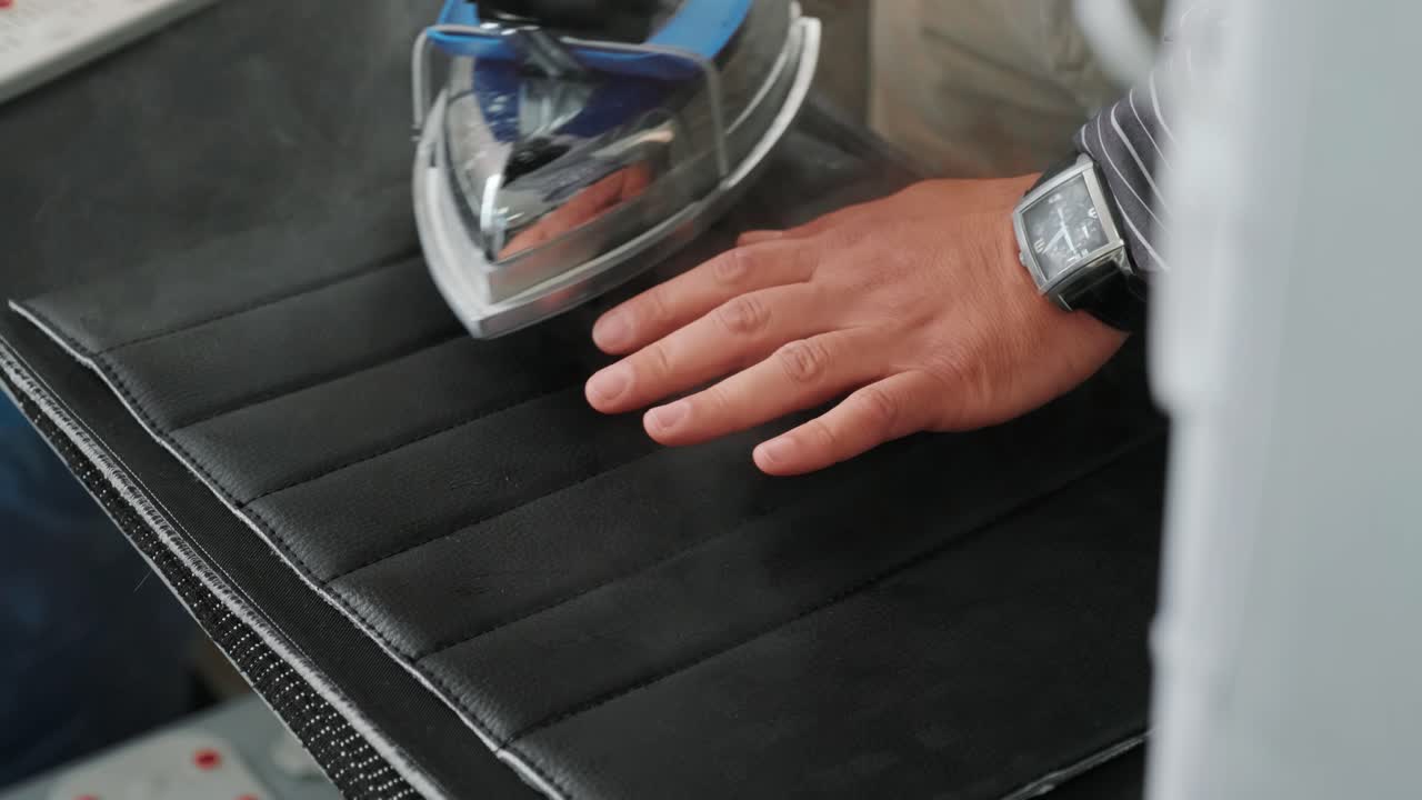 hombre hierro ropa en la tabla de planchar con hierro de vapor azul