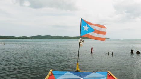 La-Bandera-De-Puerto-Rico-Ondea-Al-Viento-Al-Final-De-Un-Muelle-Pintado-Con-La-Bandera-Nacional