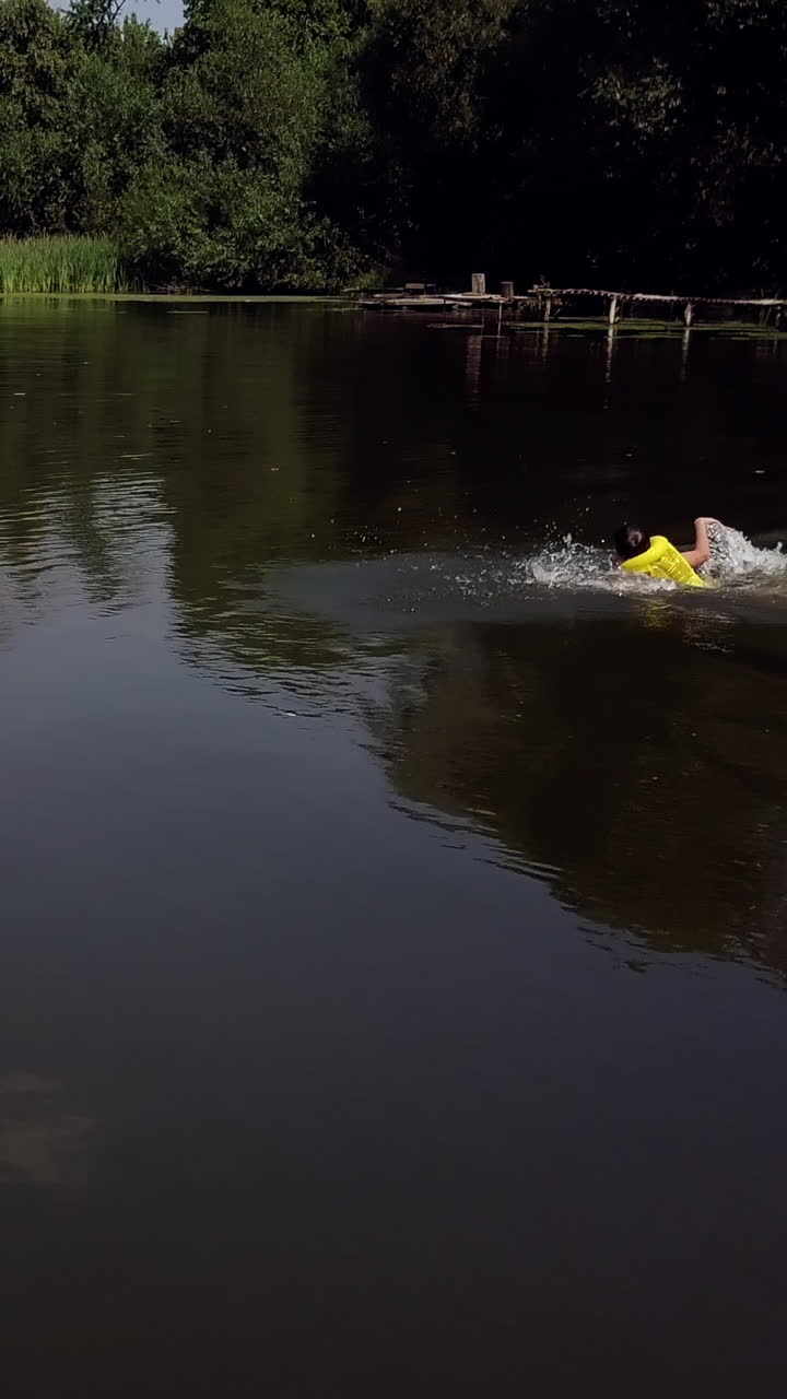 a boy is floating in the river. Aerial view. Vertical video