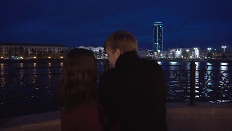 couple enjoying the night view of the city by the river