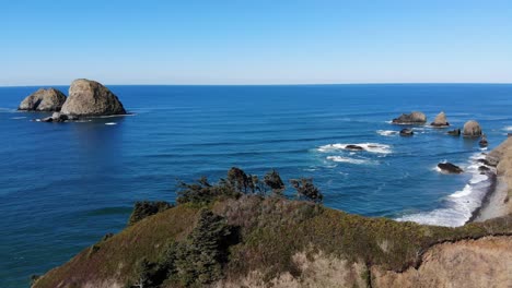 drone flies over cliff towards the ocean