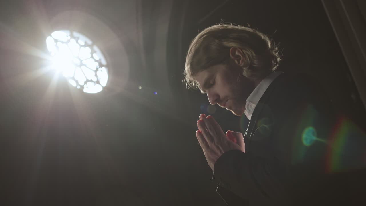 Young Handsome Caucasian Man Praying in Gothic Church