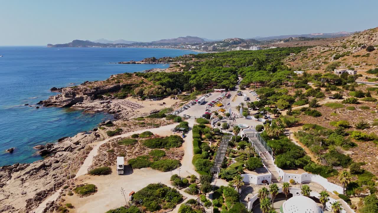 Aerial view of a coastal landscape with beach, sea, trees and mountains