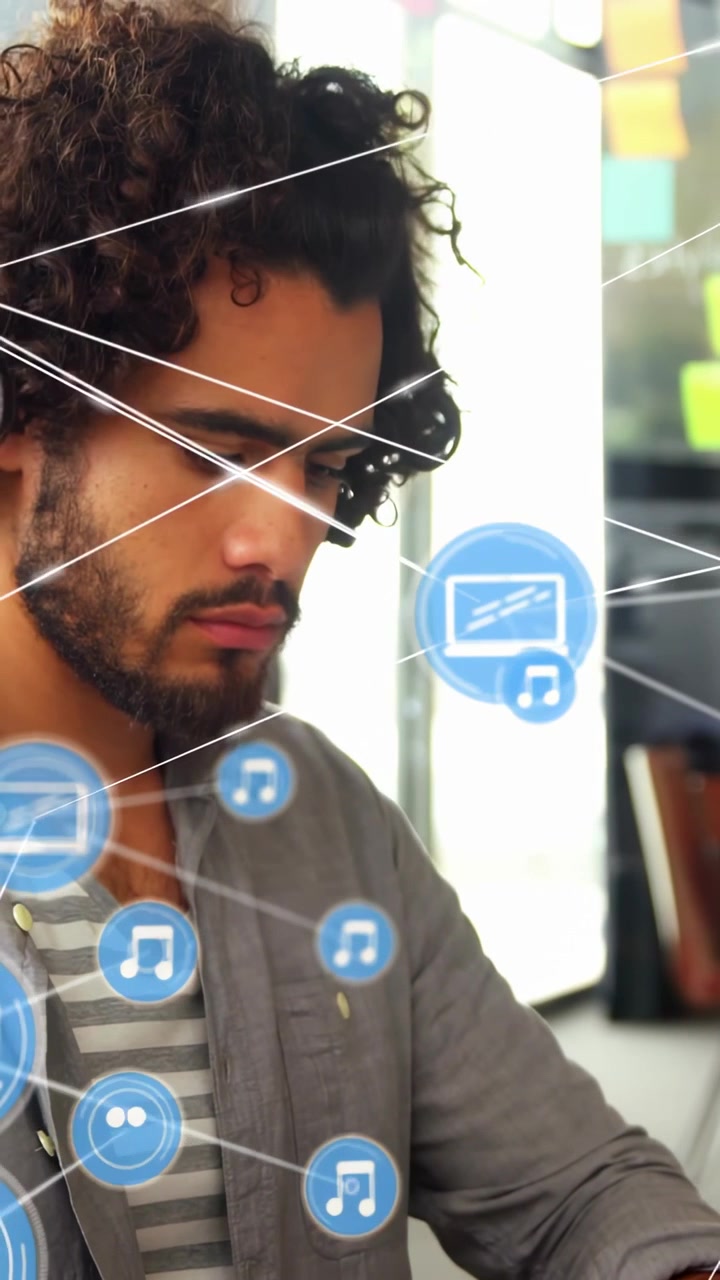 Vertical video: Man typing on laptop in tech, driving blue GUI visualizing music device icons