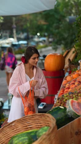 woman shopping for fruit at an outdoor market