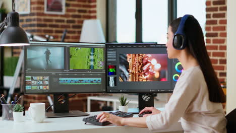 asian filmmaker woman putting headphones on and working on video production