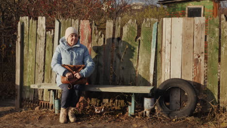 elderly woman sitting on a bench outdoors