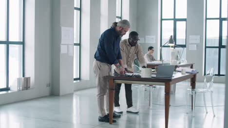 Arquitectos-Masculinos-Multiétnicos-Discutiendo-El-Proyecto-En-La-Oficina