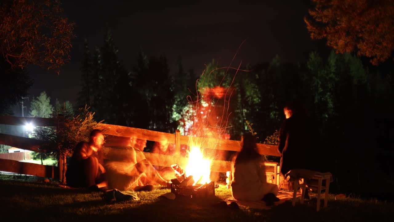 grupo de jóvenes pasando un buen rato juntos alrededor de la fogata en una ladera