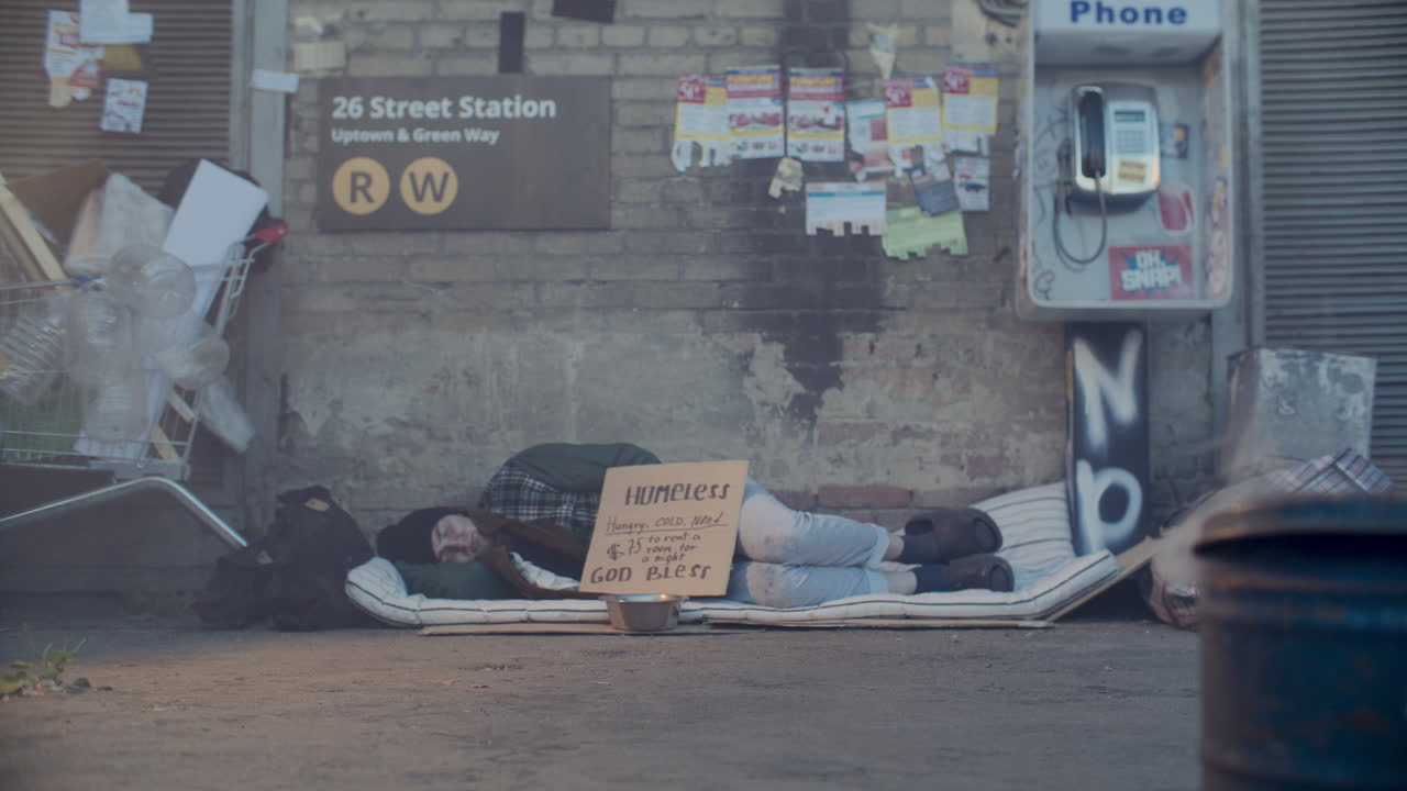 Homeless Man Sleeping Outside Subway Station on Urban Street