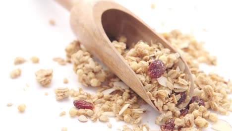 wooden scoop of granola with almonds and cranberries