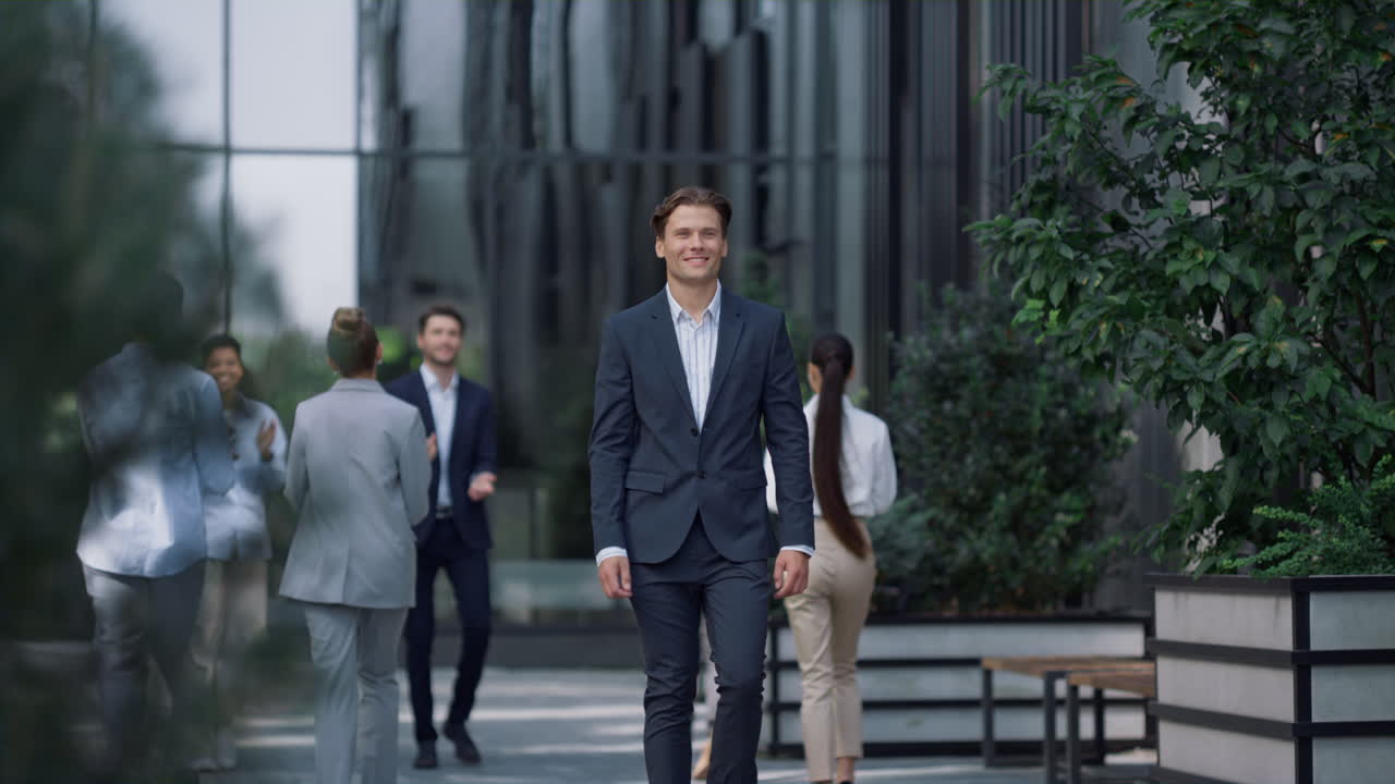 성공한 우아한 사업가가 시내를 걸어다니며 멀리서 쳐다보고 있습니다.