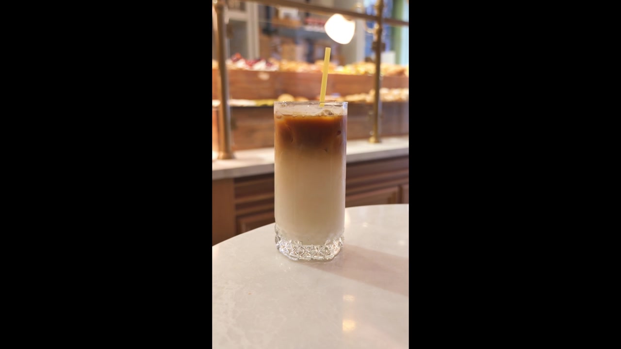 Latte macchiato freddo in un bicchiere su un tavolino da bar