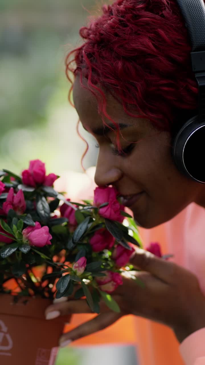Woman enjoying flowers and music outdoors