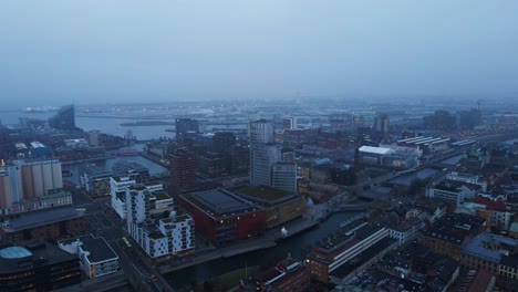 aerial of the beautiful city of malmö, sweden on a mist covered morning with high rise apartment buildings in the background