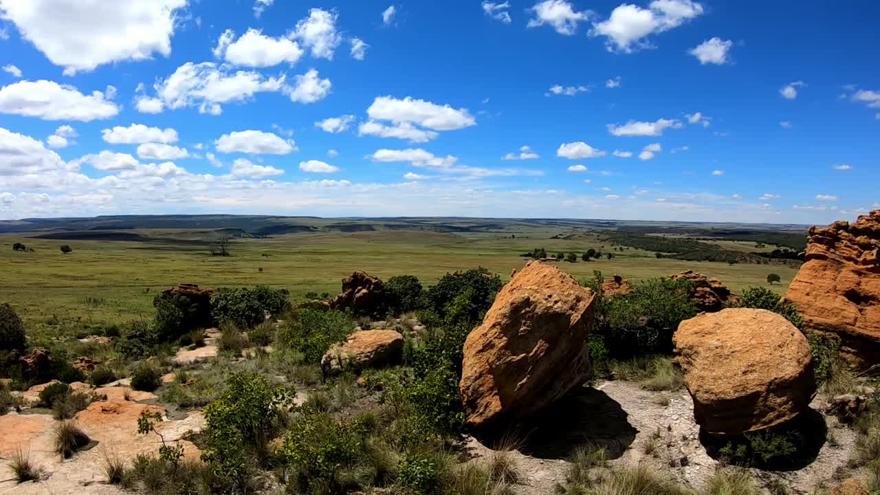 Large Natural sandstone rock formations on a hill overlooking a field