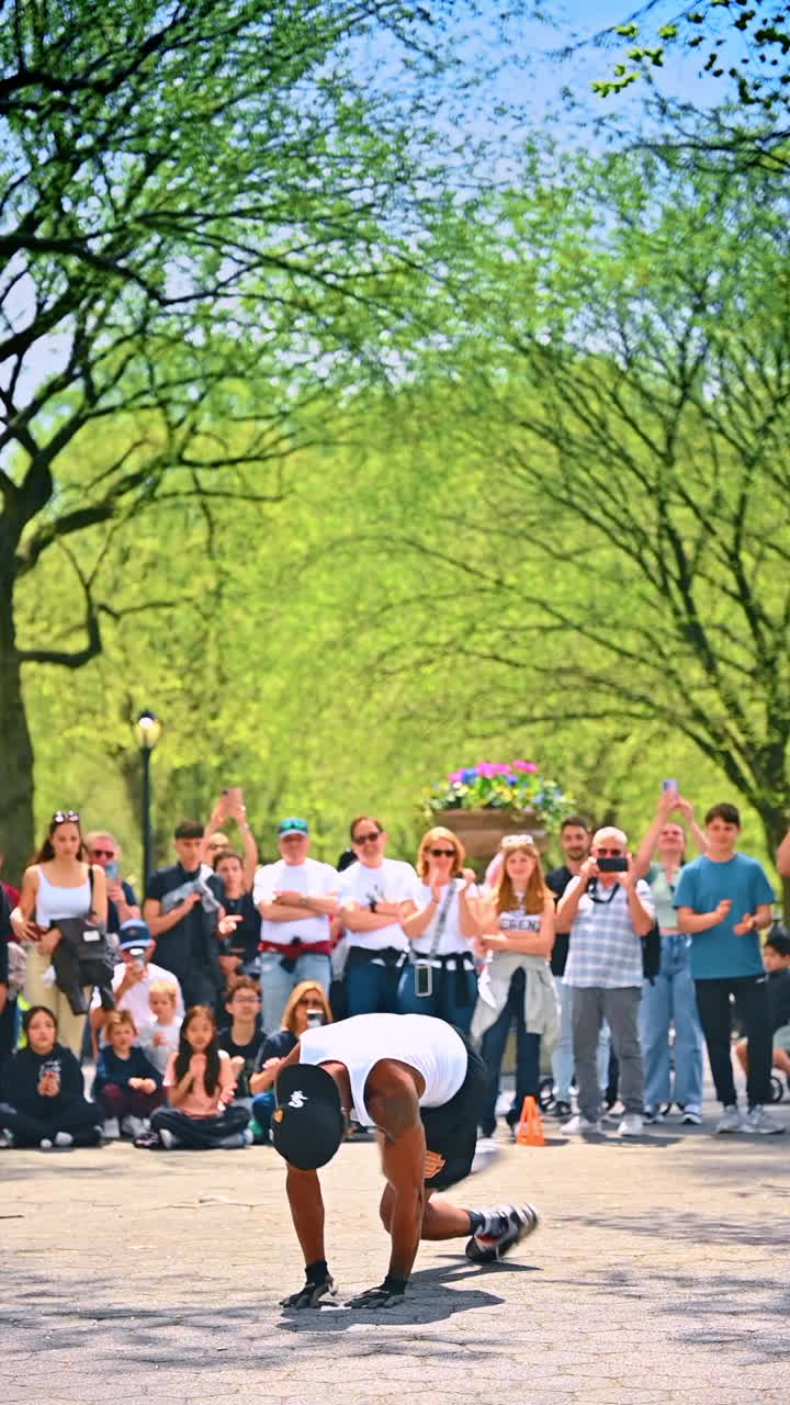 New York, USA, 8 July 2025: NYC street performer wows crowd. A skilled performer entertains a large crowd in a sunny New York park, showcasing impressive talents