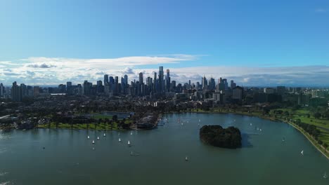 drone rising above albert park lake with sailing boats below