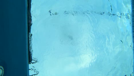 Underwater-shot-of-a-female-swimmer-swimming-in-the-lanes-across-the-pool