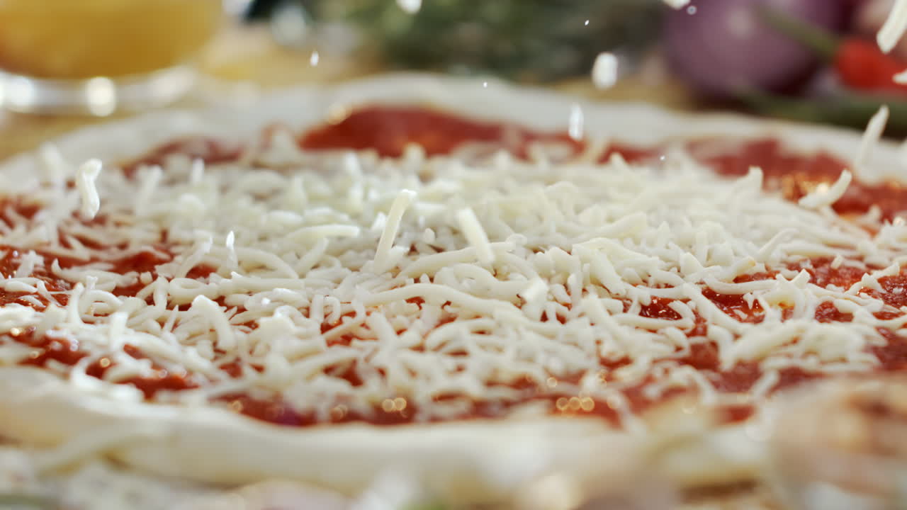 Preparing Pizza with Cheese and Tomato Sauce