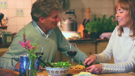 una pareja madura cenando juntos hablando.