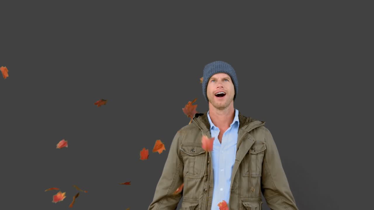 Amazed man looking at falling leaves on grey screen