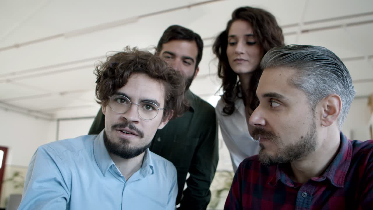 Colleghi sorridenti che fanno una videochiamata tramite laptop