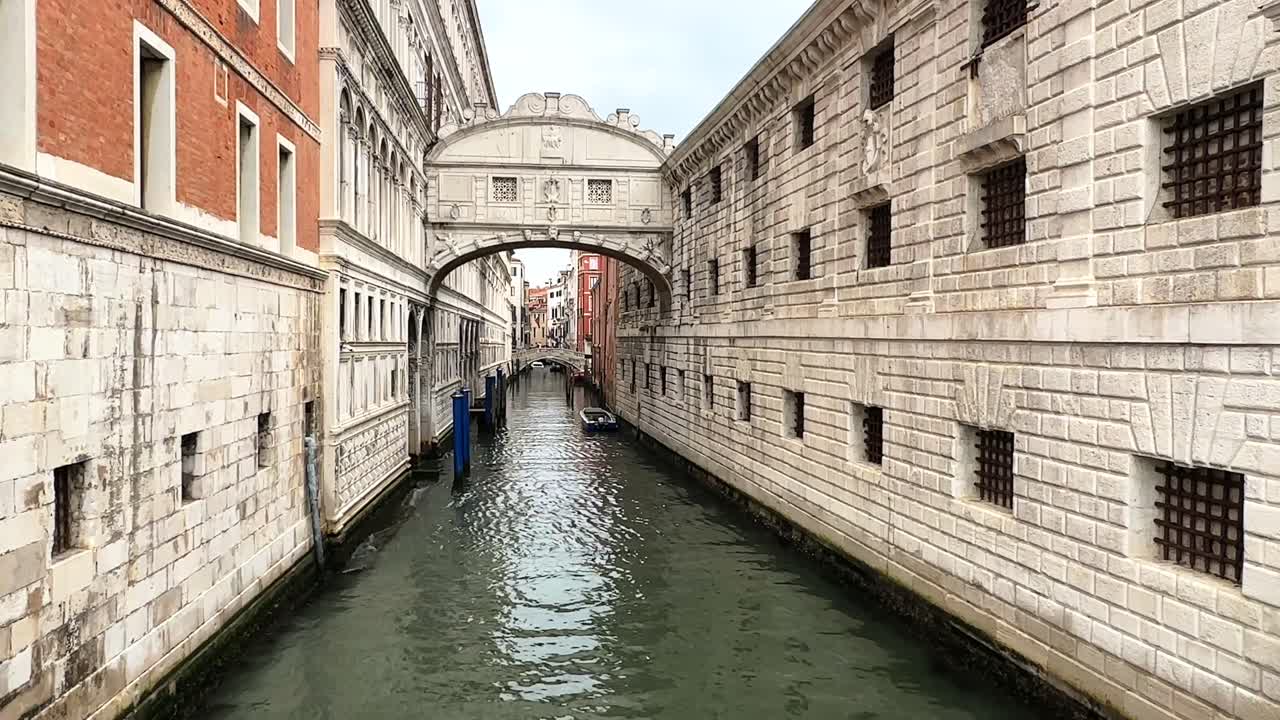 The Bridge of Sighs over a narrow Venetian canal with historic buildings on both sides