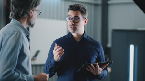 two professionals discussing work and collaborating with a tablet