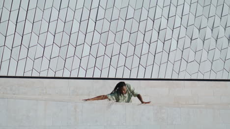 un tipo dramático ensayando el baile en la calle vertical. un hombre acrobático bailando estilo libre.